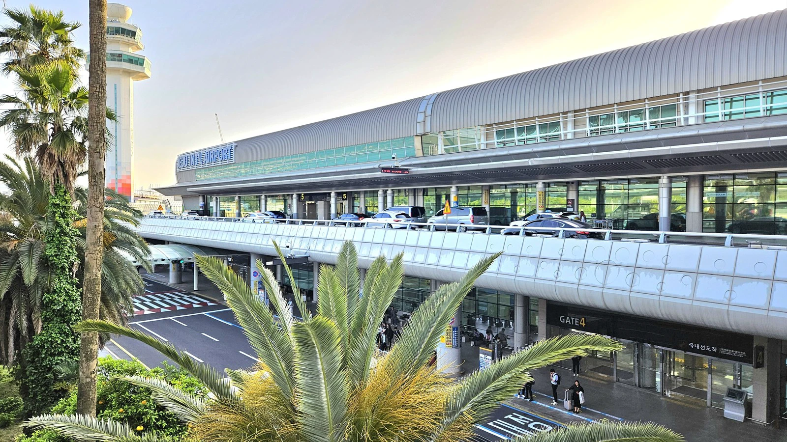 Nhà ga Sân bay Quốc tế Jeju sau hàng cọ trong ánh hoàng hôn