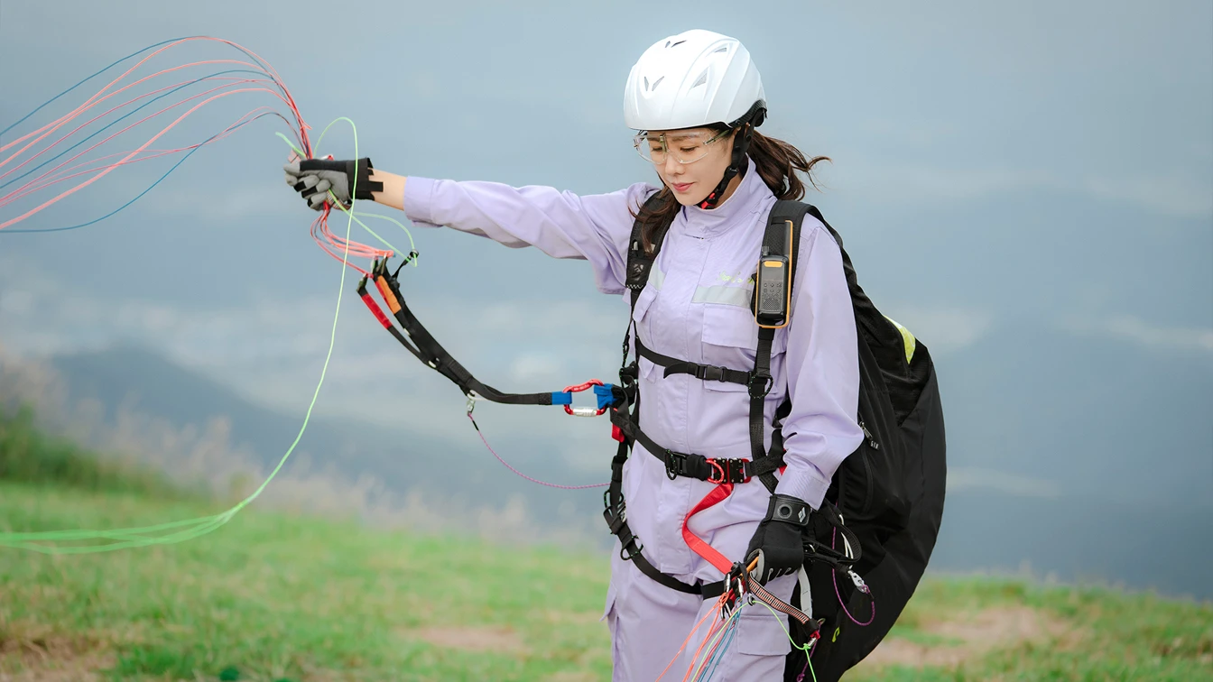 Yoon Se-ri untangling paragliding lines on a hillside in Crash Landing on You