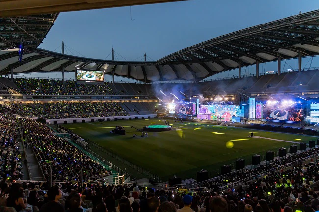 Audience watching a large outdoor concert stage at Seoul World Cup Stadium