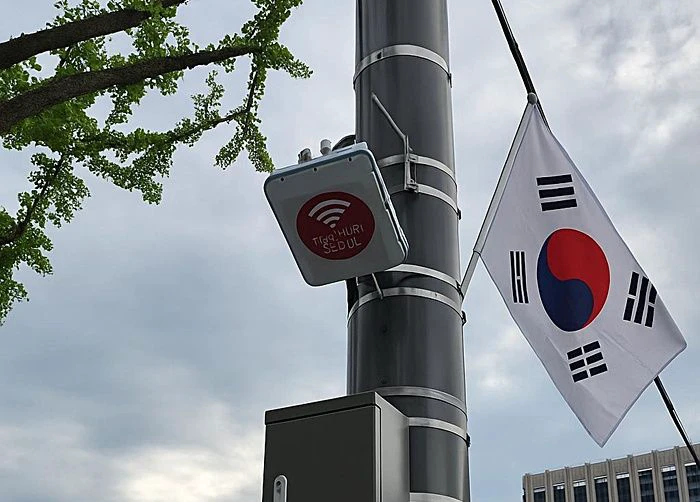 A Seoul public Wi-Fi access point mounted on a street pole beneath Korean and Seoul city signs