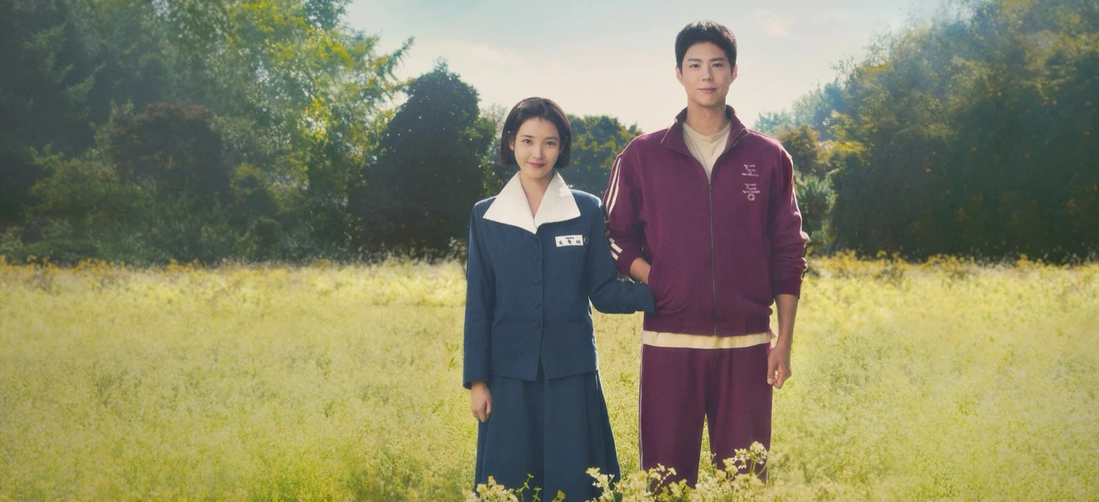 IU and Park Bo-gum standing in a field in official When Life Gives You Tangerines key art