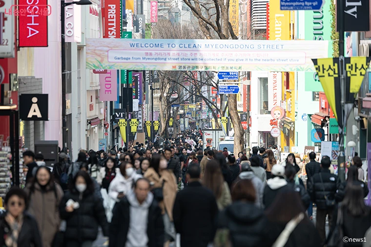 Crowds walking between shops on Myeongdong's main shopping street