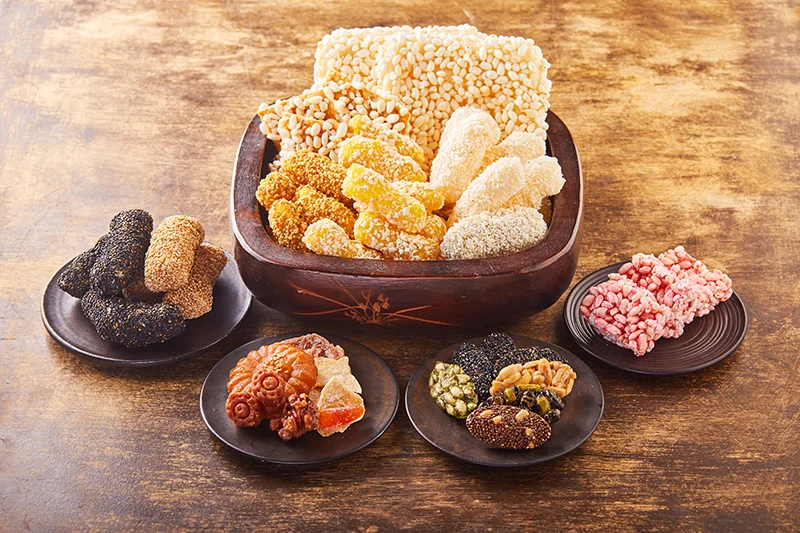 Assorted Korean hangwa sweets arranged on dark wooden plates