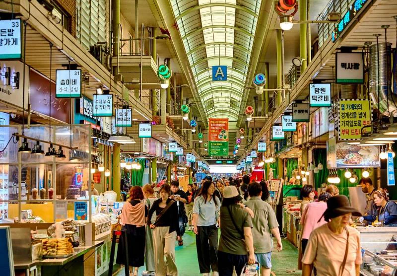 Covered aisle lined with food stalls inside Mangwon Market in Seoul
