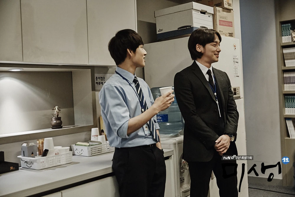 Two office colleagues talking beside a water dispenser in the tvN drama Misaeng