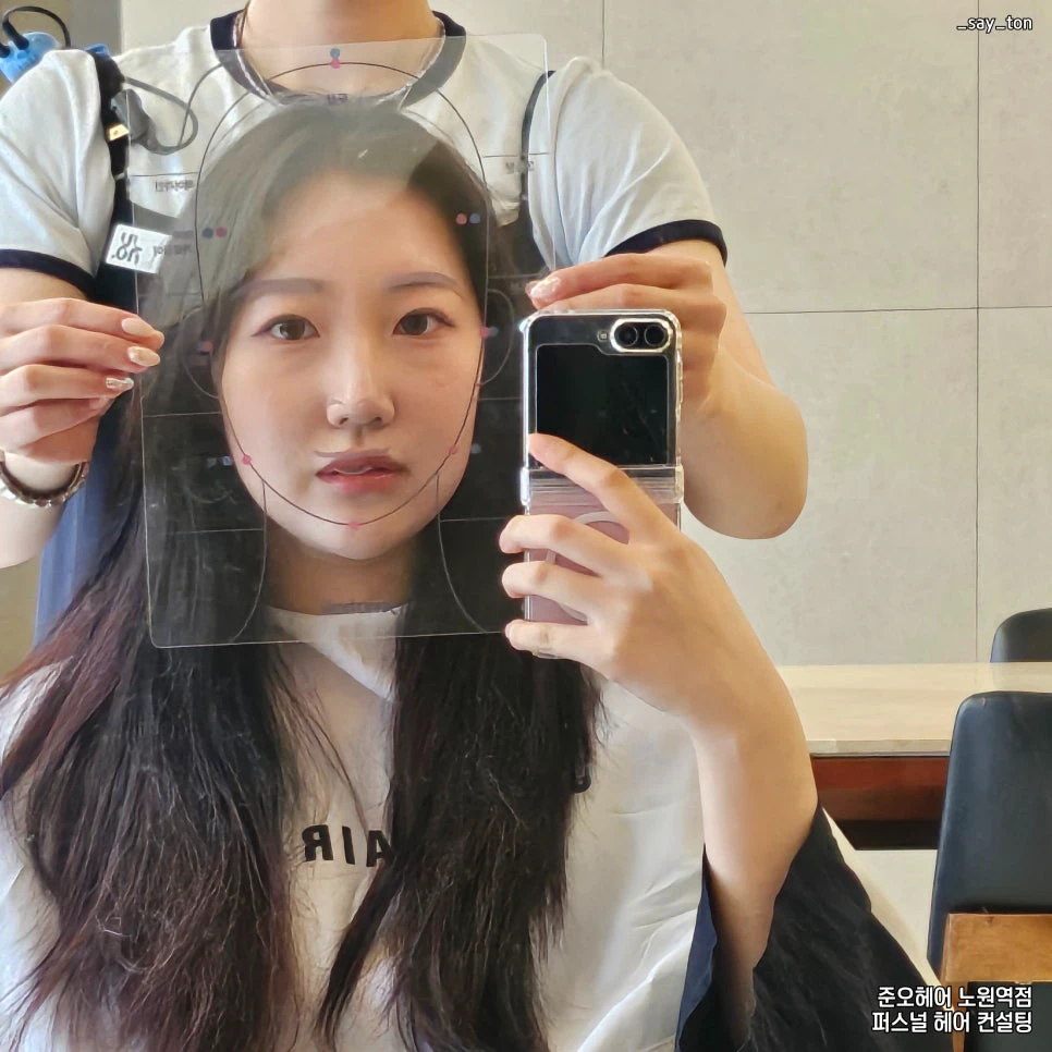 Seoul salon consultation using a transparent face-proportion guide before a haircut