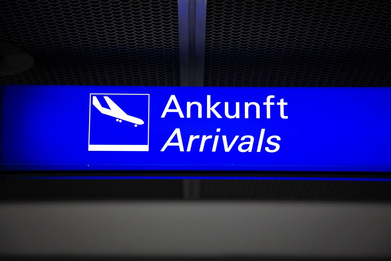 Blue airport arrivals sign with a landing airplane symbol