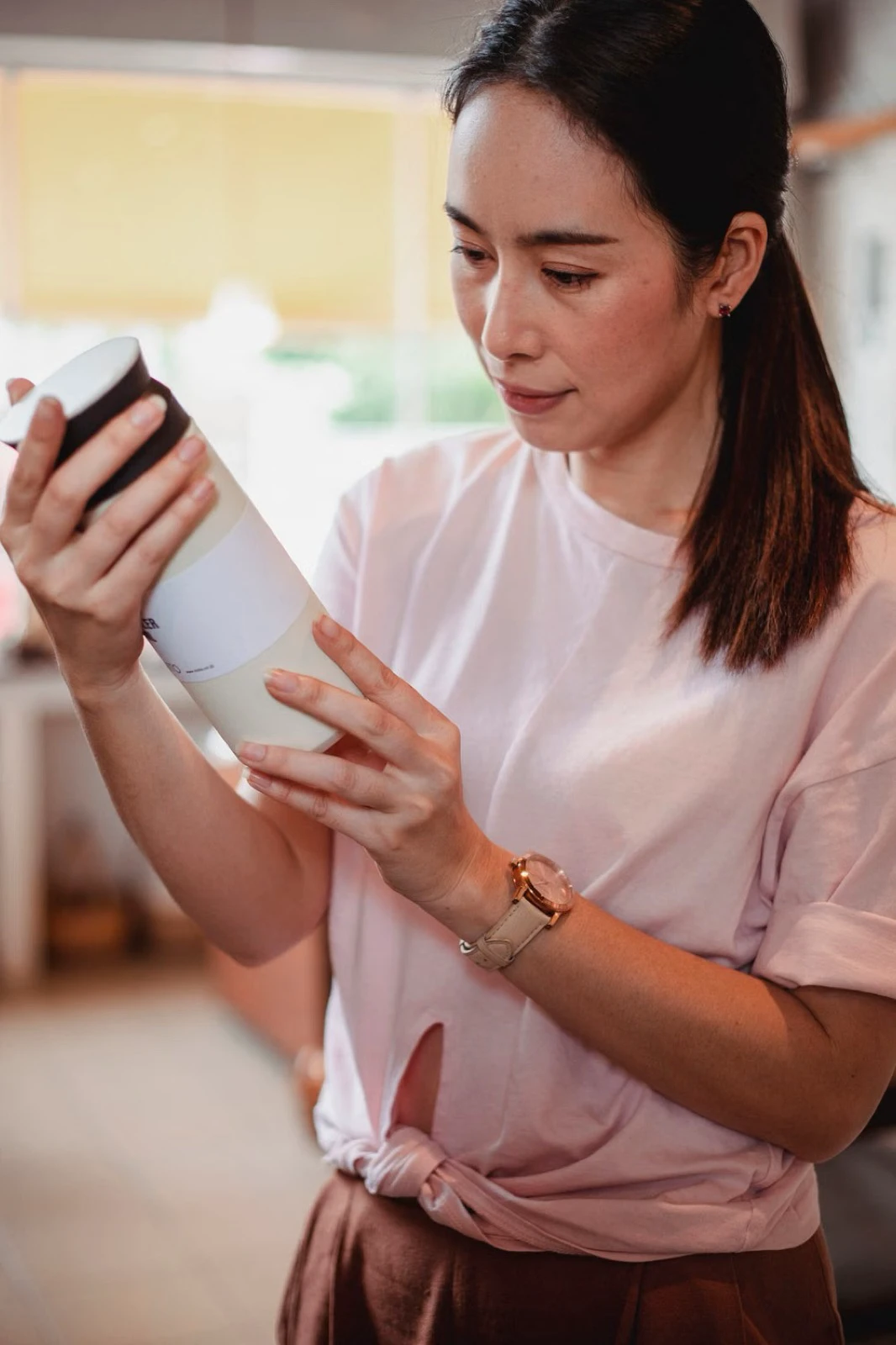 Người mua xoay chai mỹ phẩm để đọc nhãn kỹ