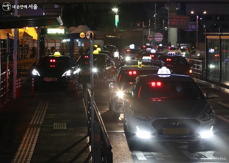 Deretan taksi Seoul dengan lampu menyala menunggu di tepi jalan pada larut malam