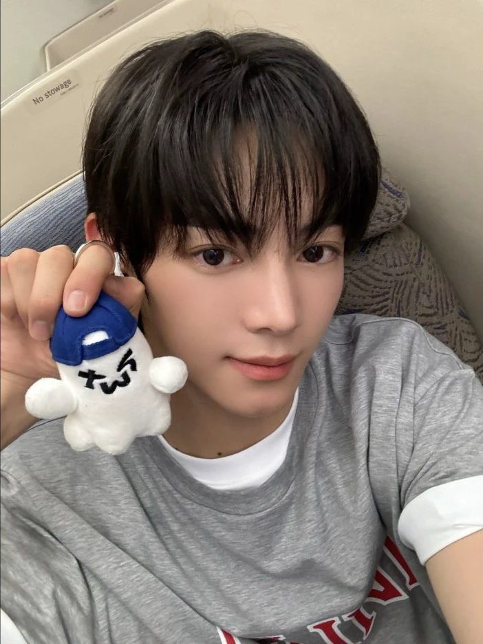 TWS member holding a small blue and white plush keyring
