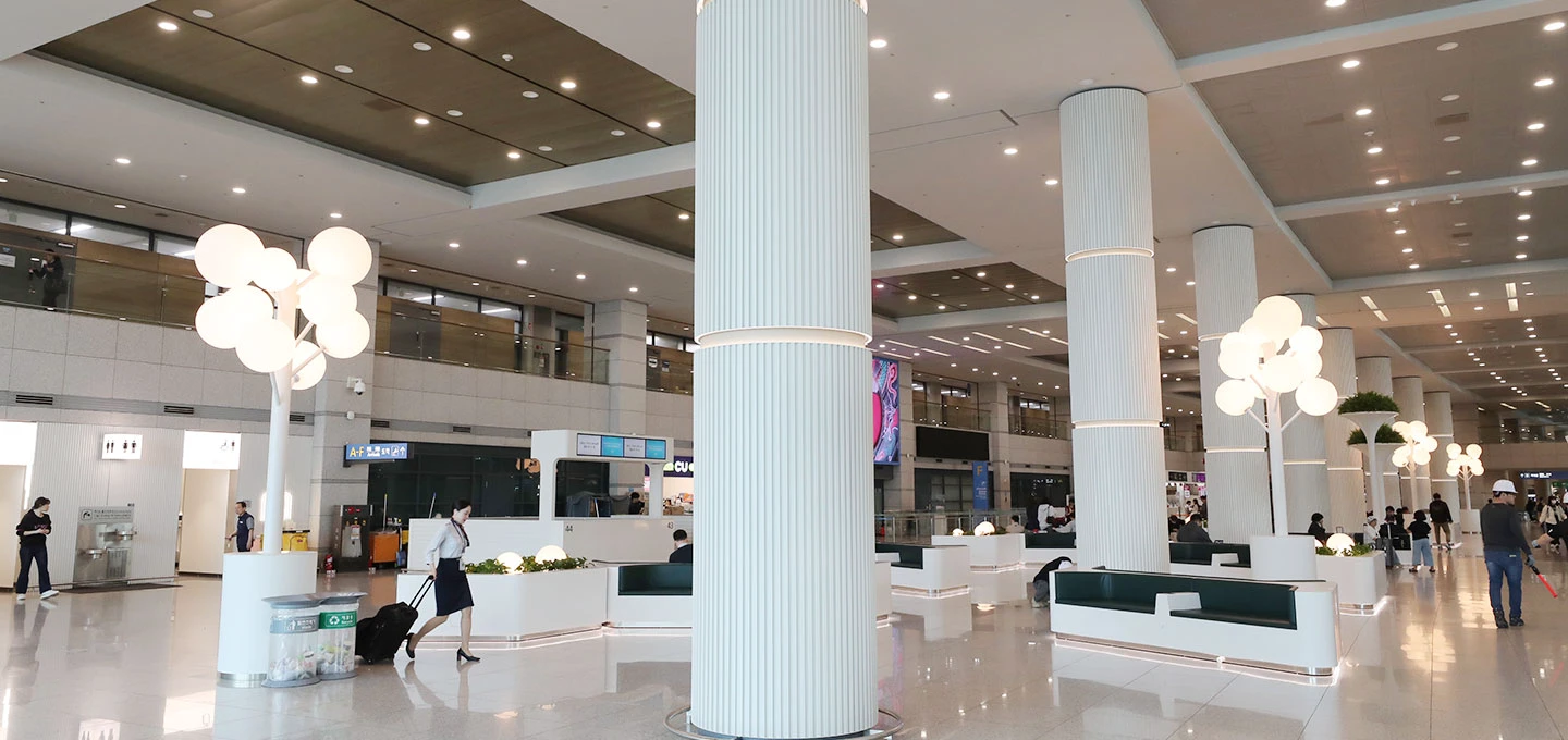 Bright public arrivals hall with seating and an information counter at Incheon Airport