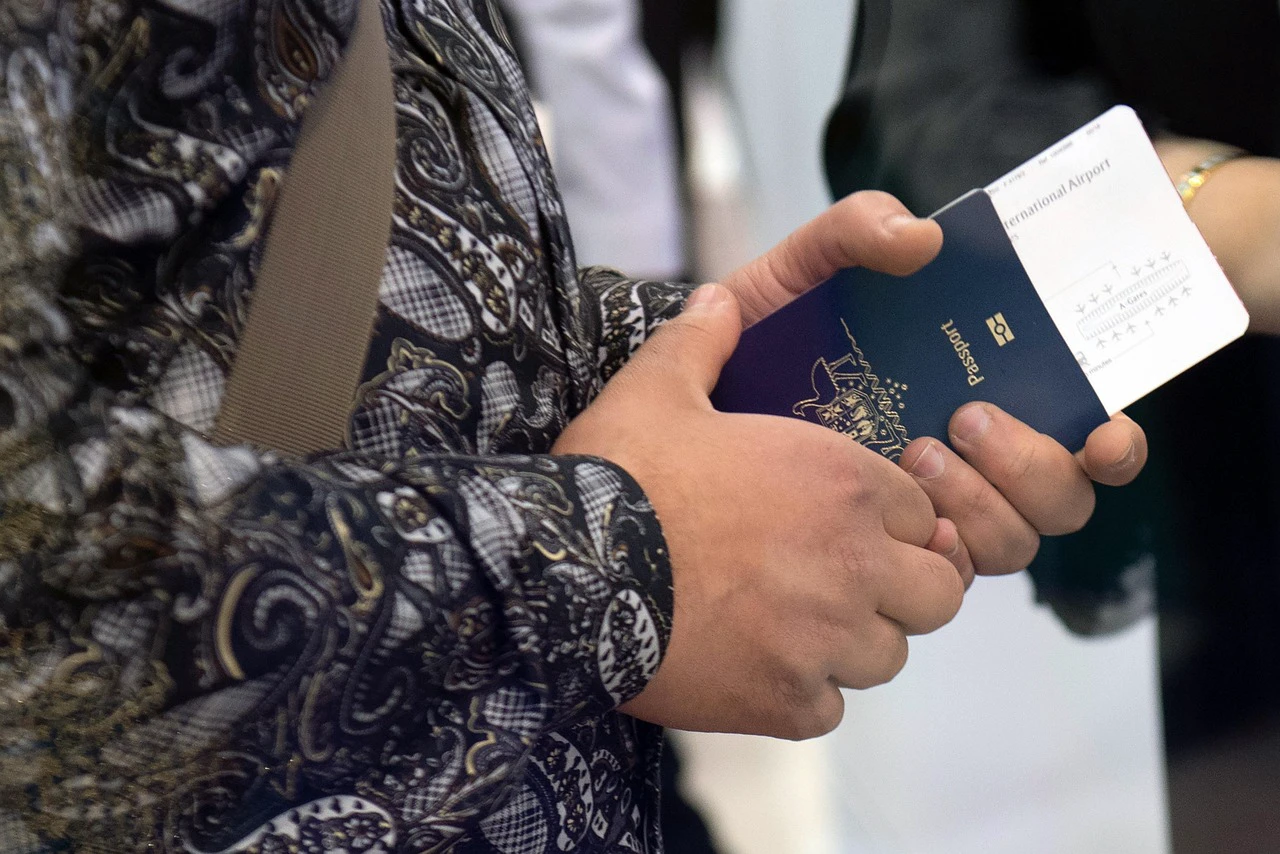 Traveler holding a passport and boarding pass before an international flight