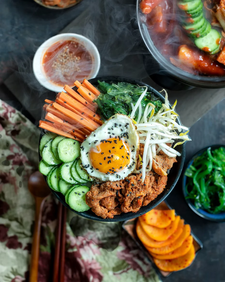 Korean rice bowl with vegetables and egg arranged separately before mixing