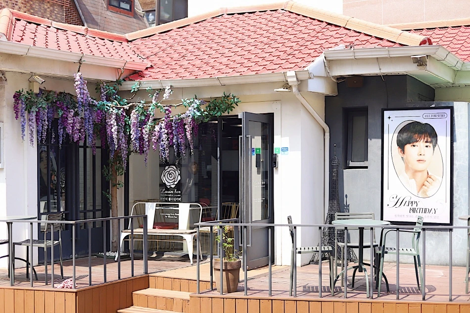 紫の花と誕生日ポスターで飾られたLovin' Her Flower Cafe外観