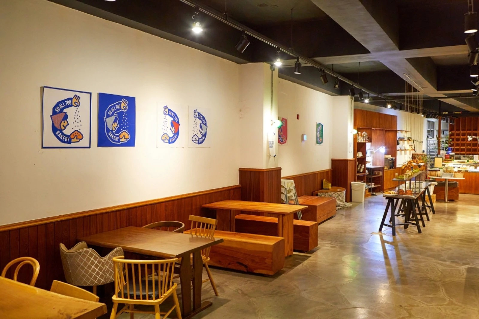 Không gian bakery café rộng với nhiều kiểu ghế gỗ và quầy bánh mở
