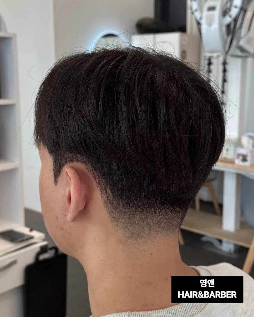 Back view of a Korean men's cut with a low, softly blended neckline