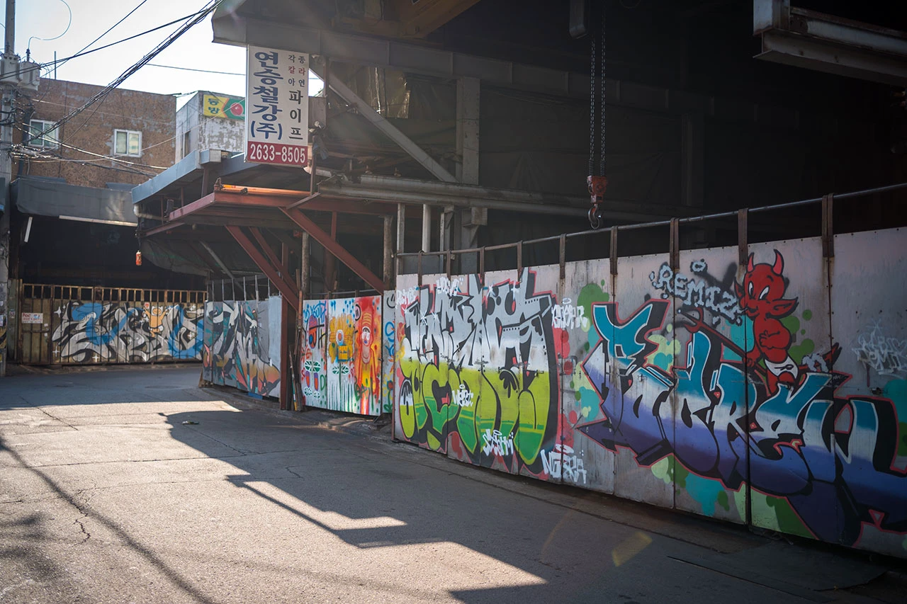 Cửa xưởng kim loại phủ graffiti ở Mullae Art Village vào buổi chiều