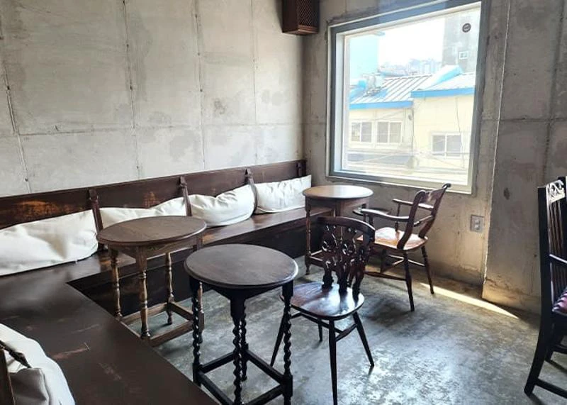 Khu ngồi với bàn ghế nhỏ bên trong quán Mailroom ở Seoul