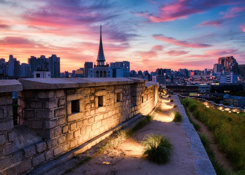 Lối đi tường thành Seoul lên đèn dưới bầu trời hồng xanh ở công viên Naksan