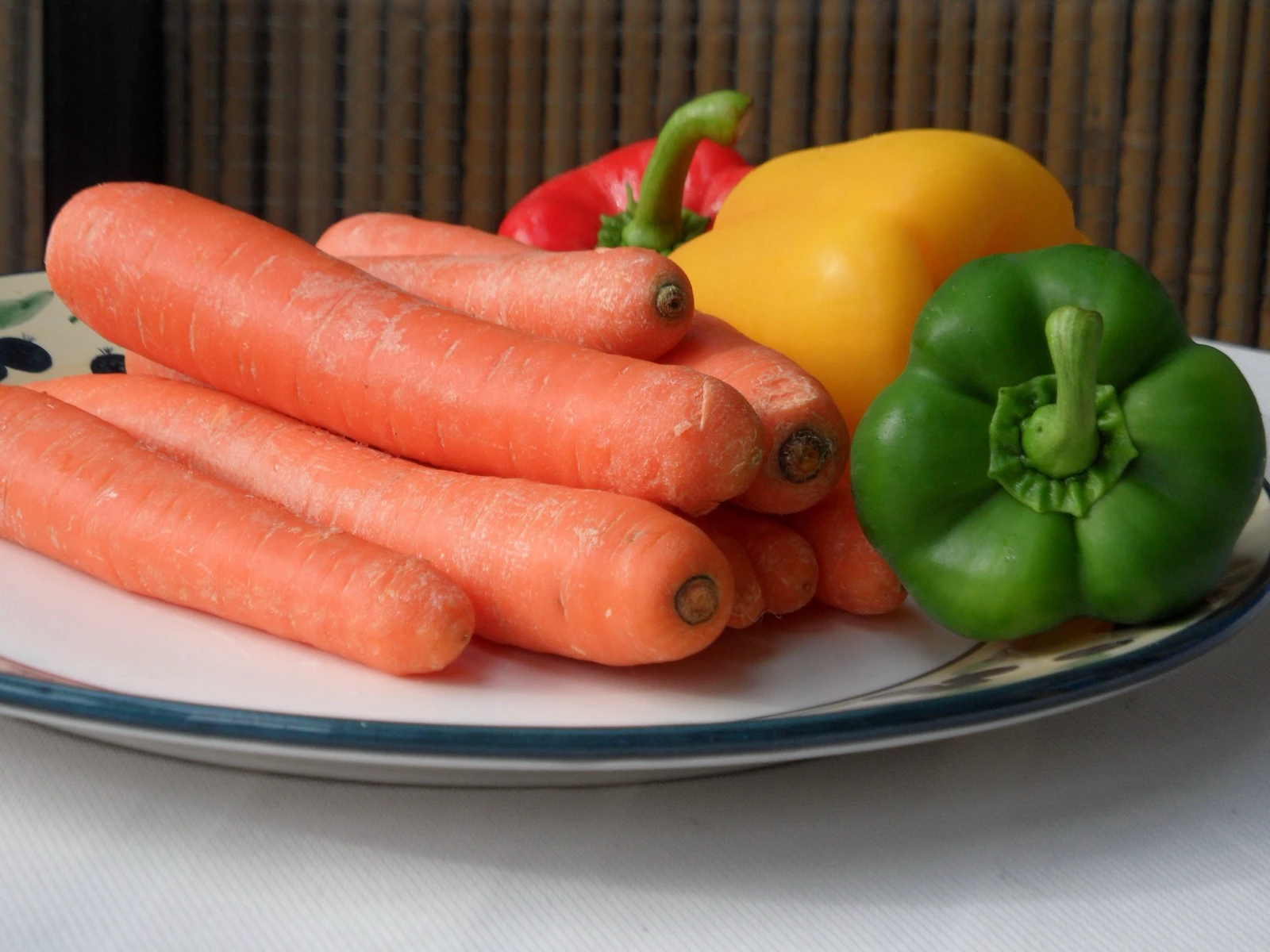 Whole carrots and red, yellow, and green bell peppers before seasoning