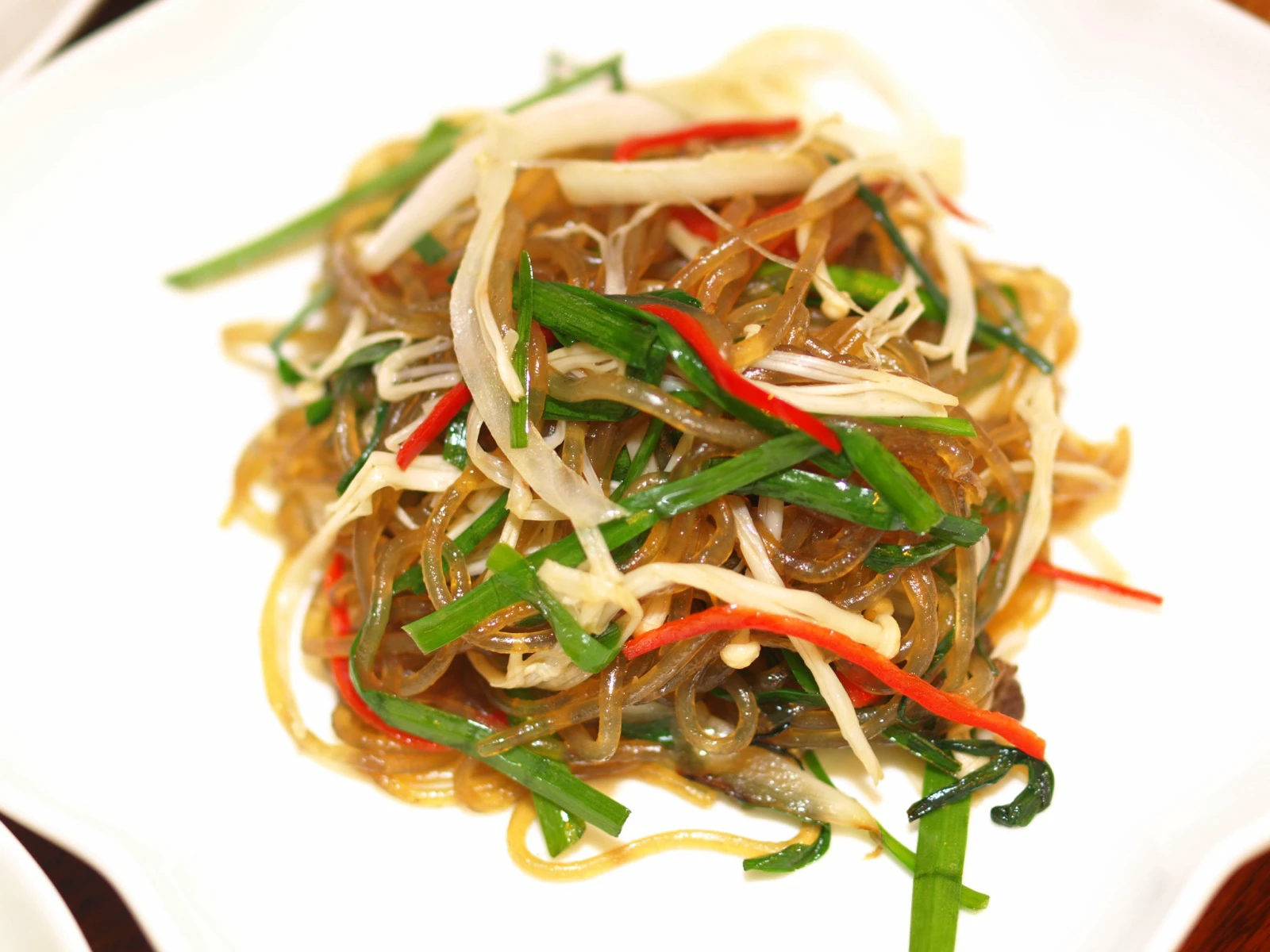 Plate of japchae with transparent sweet-potato noodles and vegetables