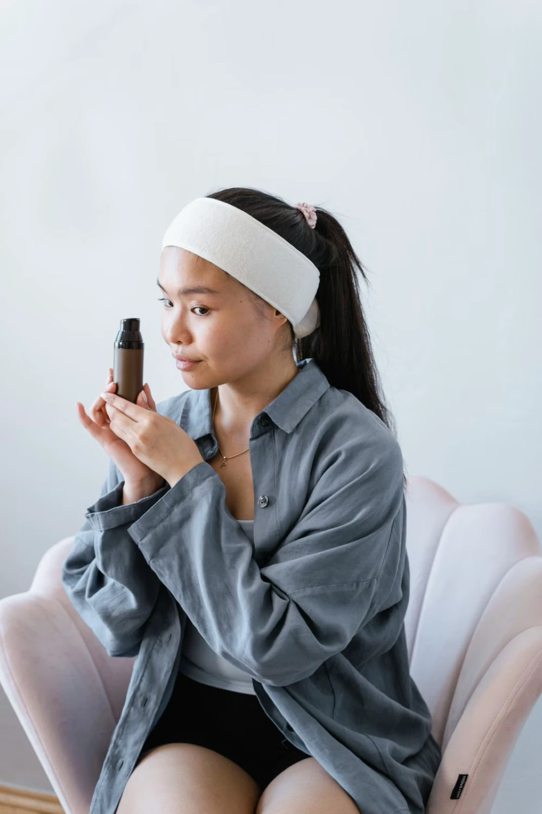 Người trẻ đưa chai vòi bơm lại gần để đọc nhãn