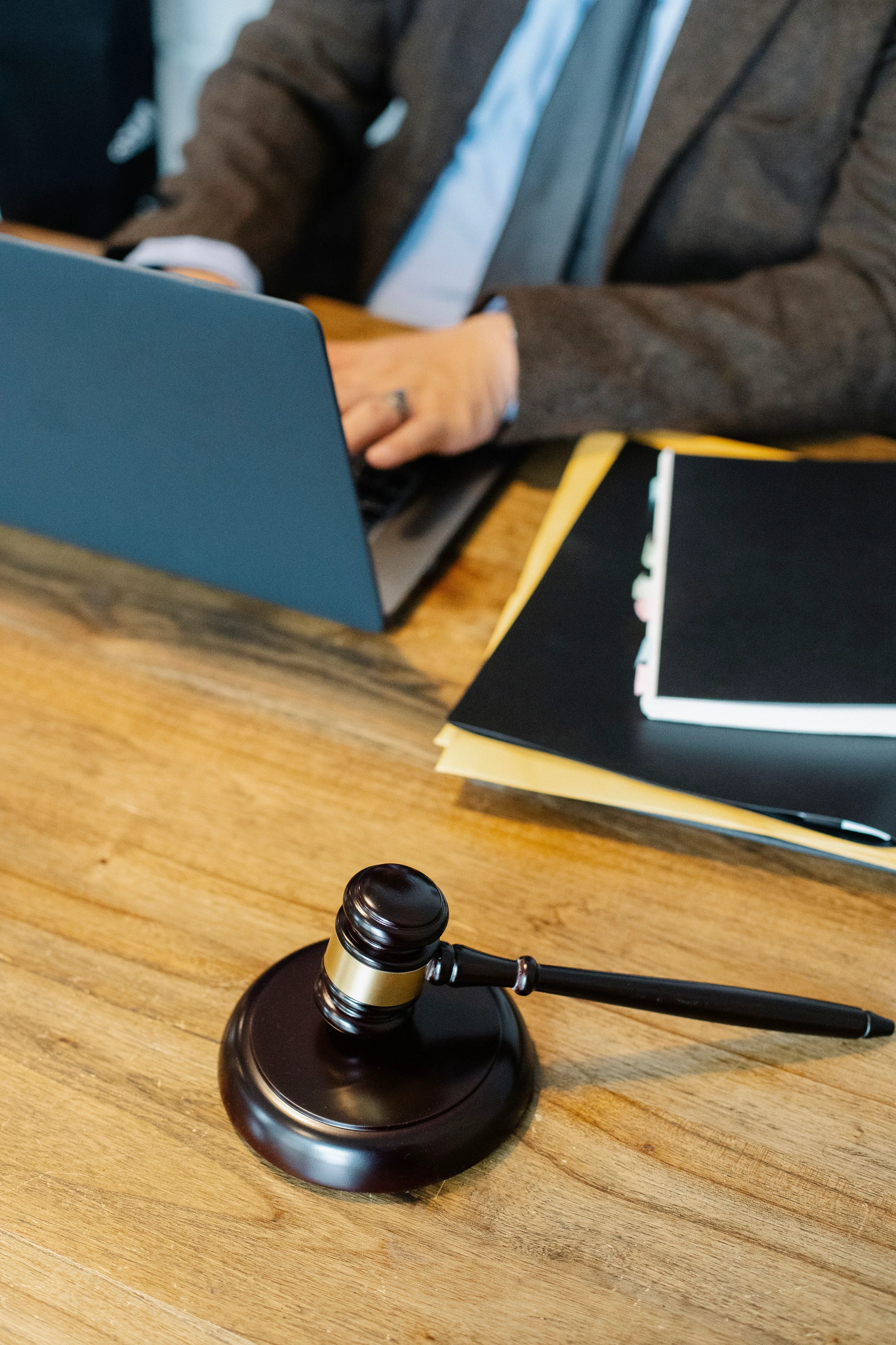 A legal professional working beside documents and a wooden auction gavel