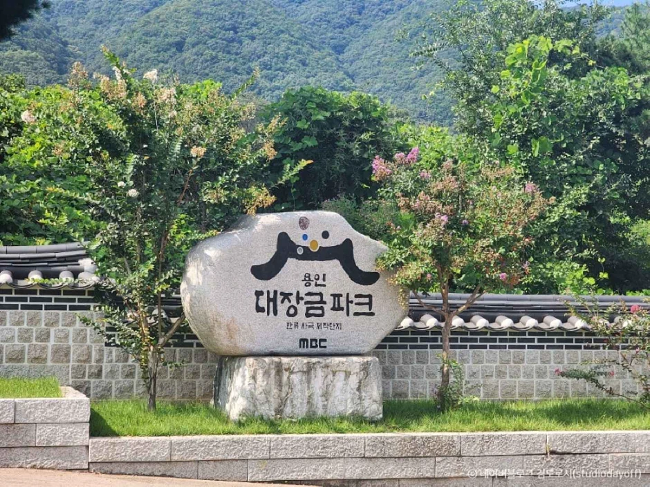 Biển đá MBC Dae Jang Geum Park trước tường ngói và cây