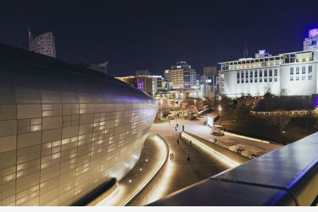 Dongdaemun Design Plaza and surrounding Seoul buildings illuminated at night