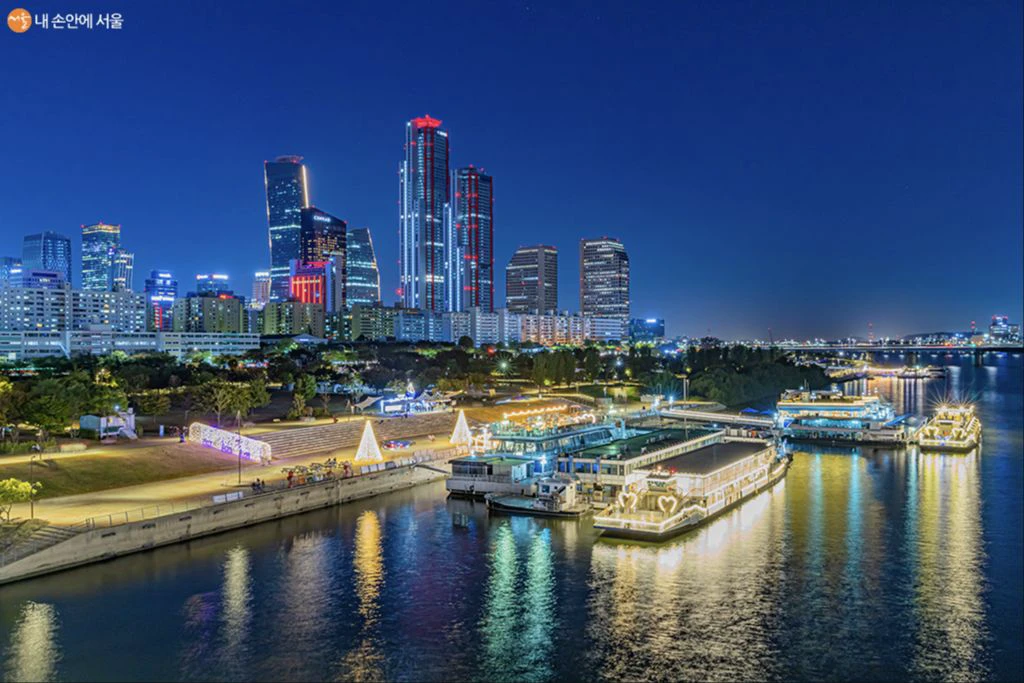 Illuminated Yeouido skyline and river wharf seen at night