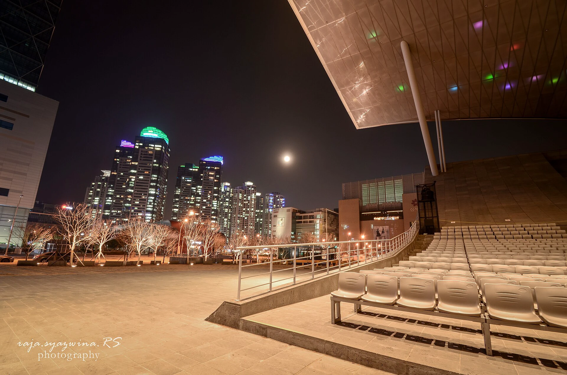 Busan Cinema Center bercahaya pada malam hari di samping cakrawala Centum City