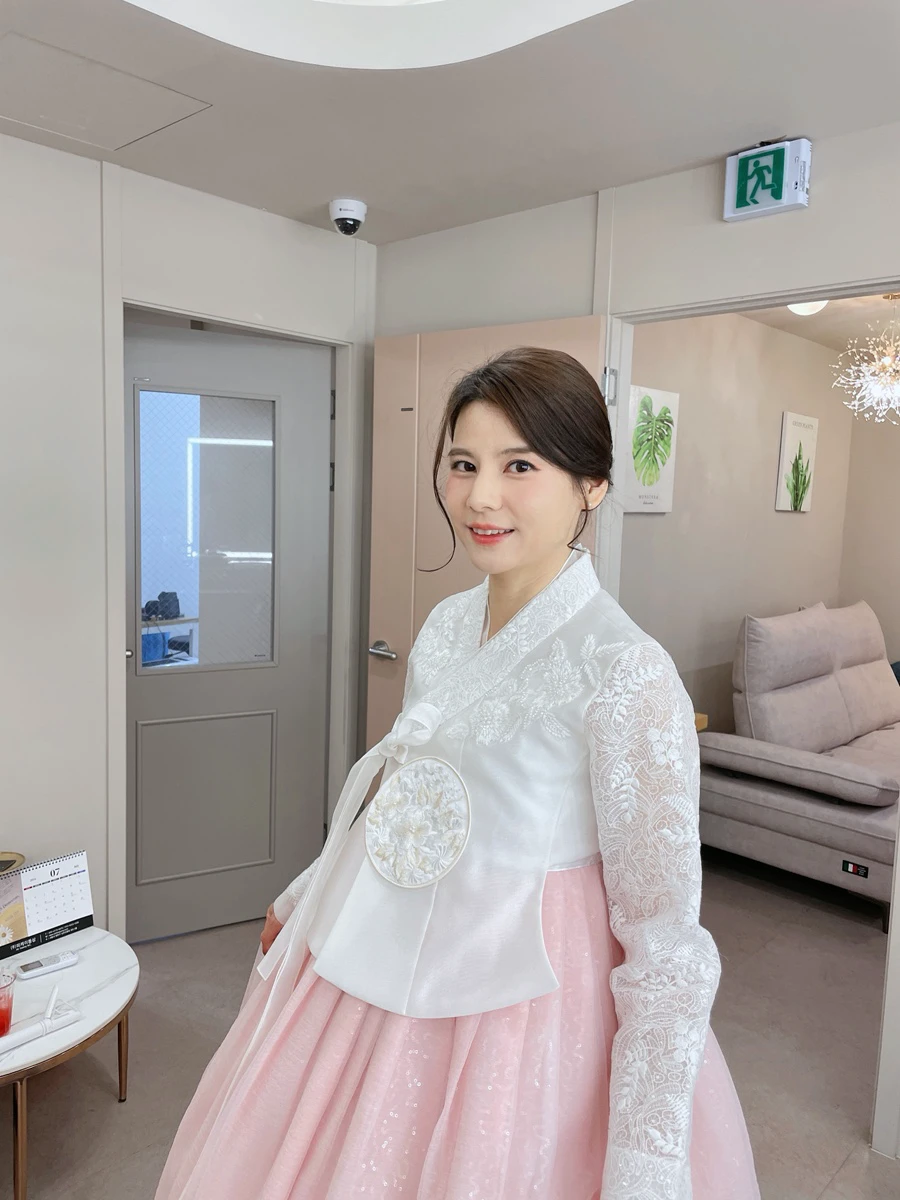 Woman in a white and pink hanbok after professional hair and makeup