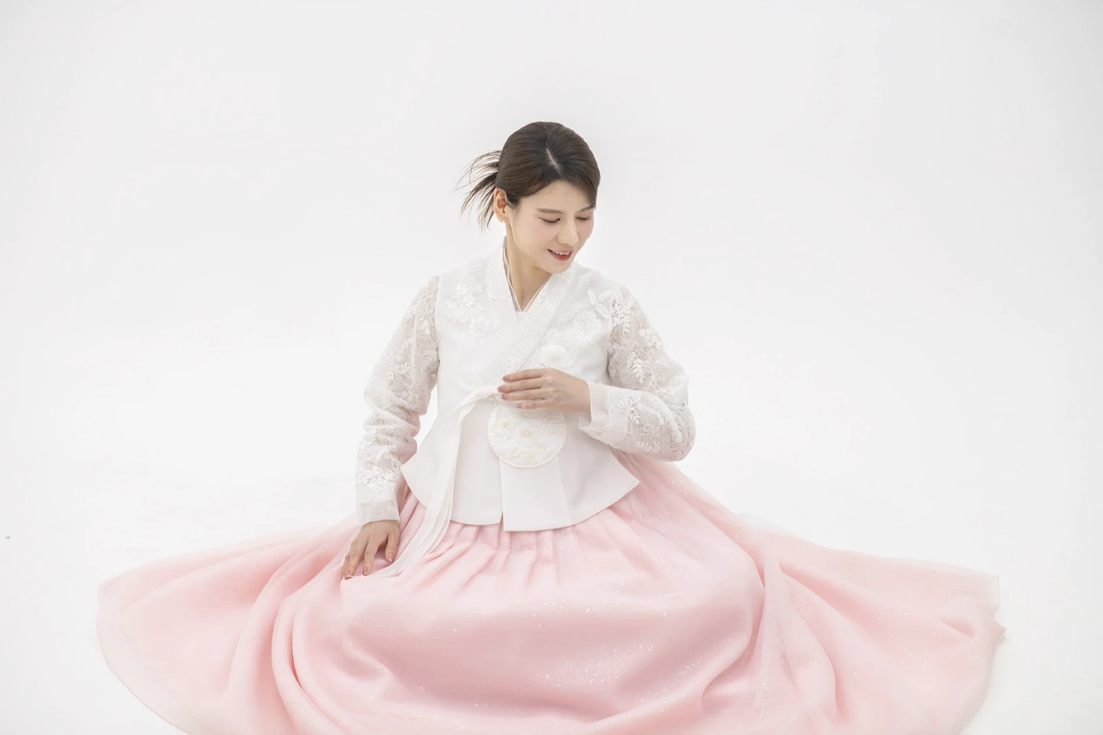 Người phụ nữ mặc hanbok trắng hồng sau khi làm tóc và trang điểm chuyên nghiệp