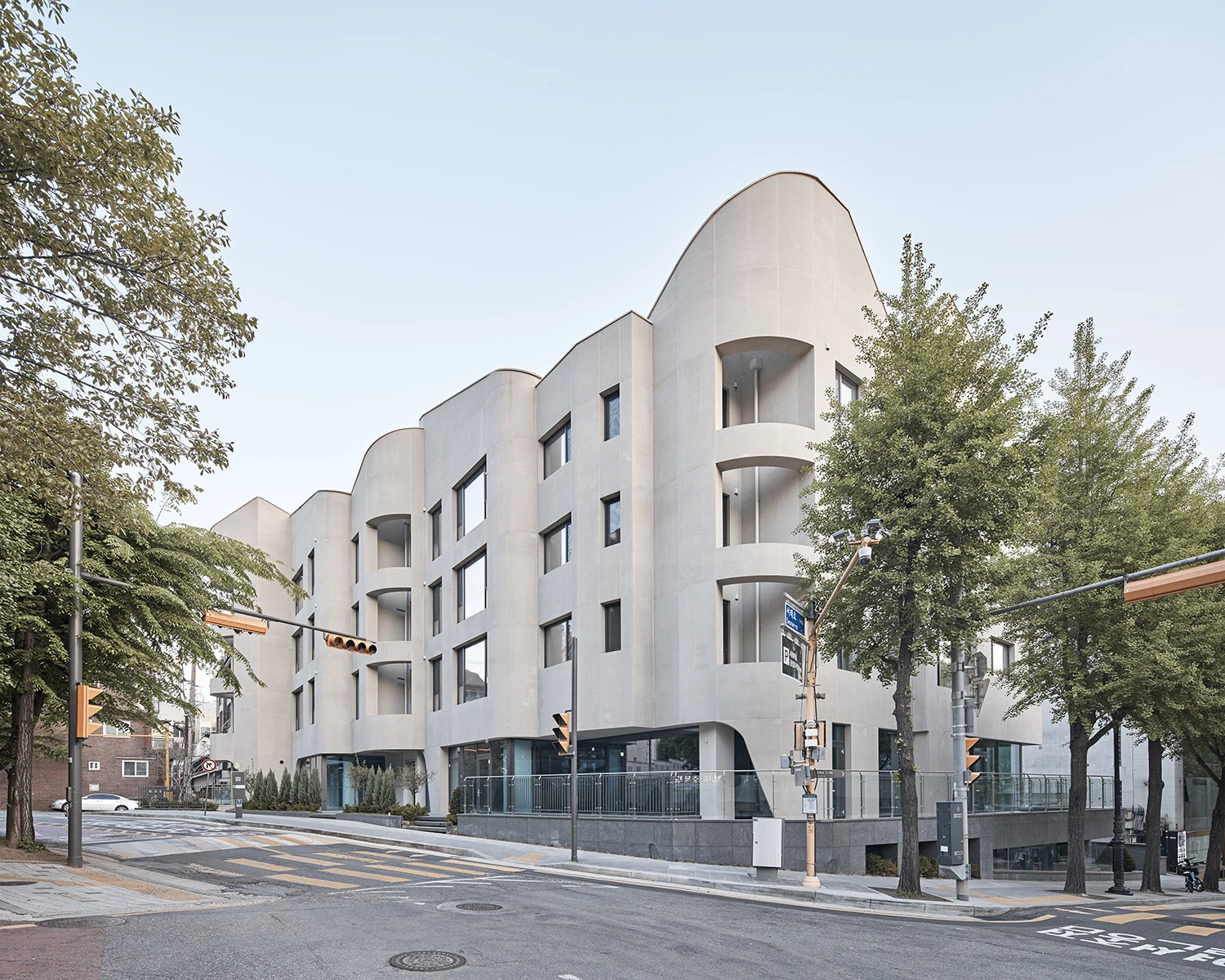 Four-story boutique multi-family housing on a tree-lined Seoul street
