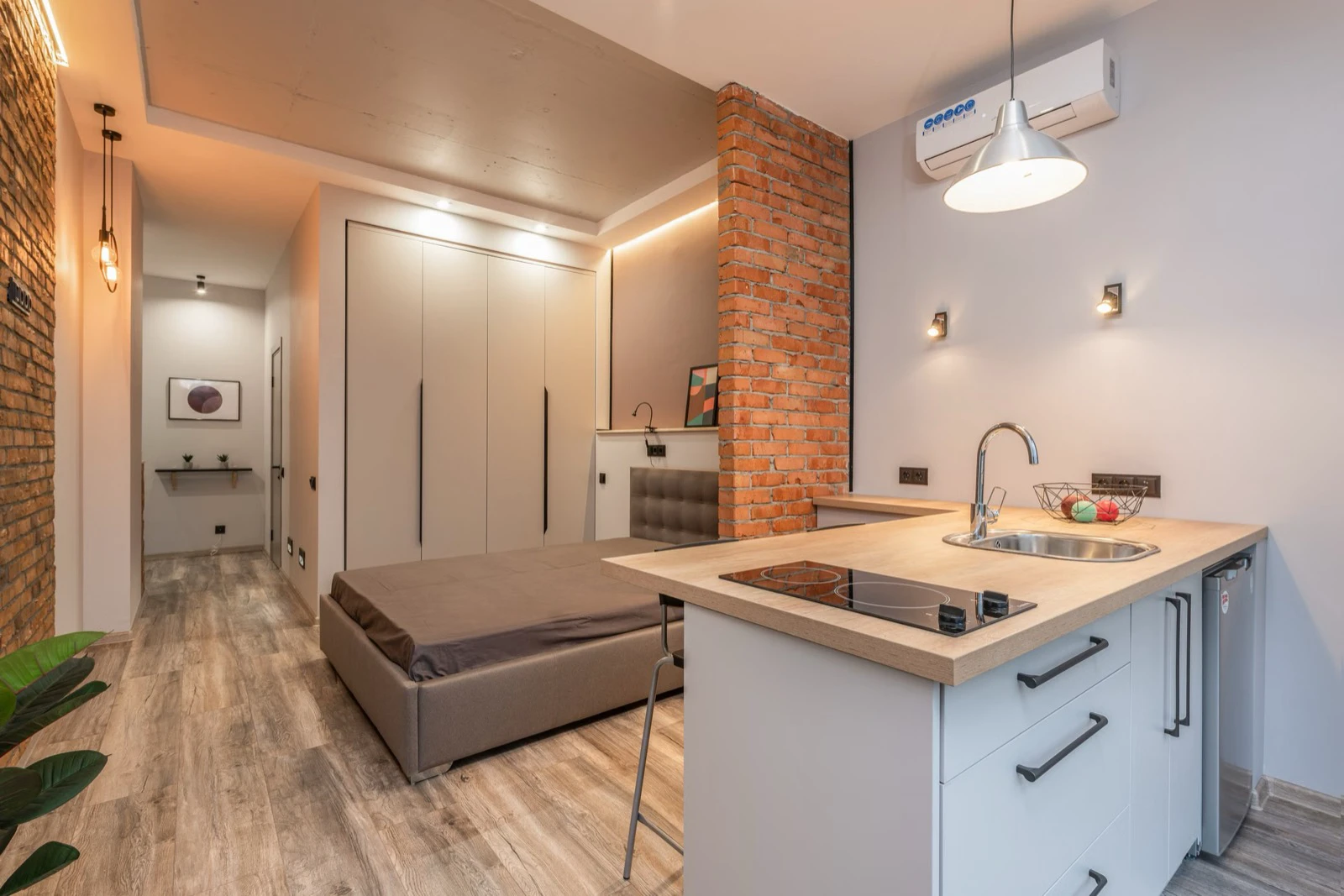 Compact studio with a bed, open kitchen and built-in storage