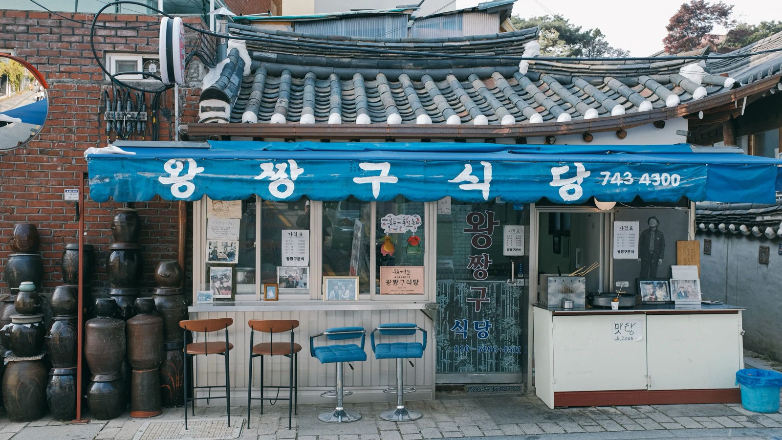 Traditional Korean restaurant facade with signs and an open doorway in Seoul