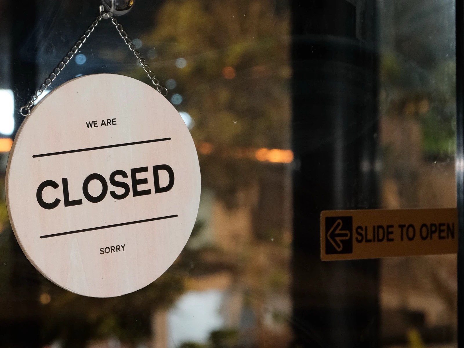 A closed sign hanging on a glass restaurant door after service