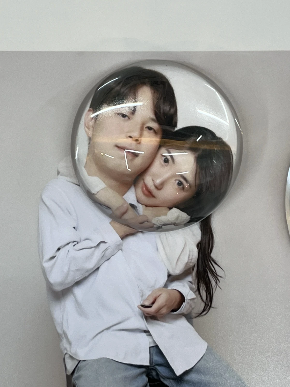 Couple testing a playful convex mirror prop during a Seoul self-photo studio visit