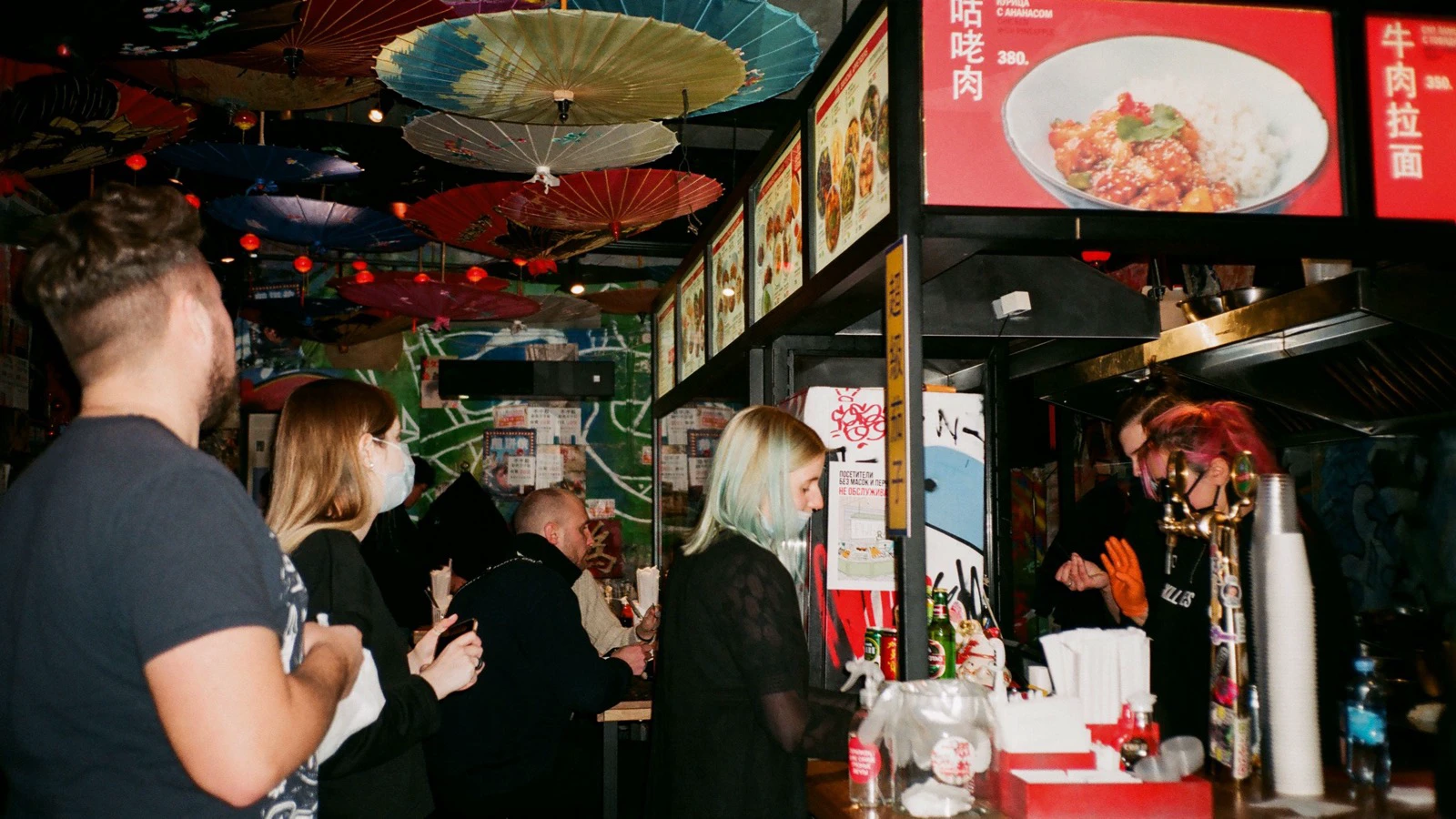 Customers forming a queue at a busy Asian restaurant counter