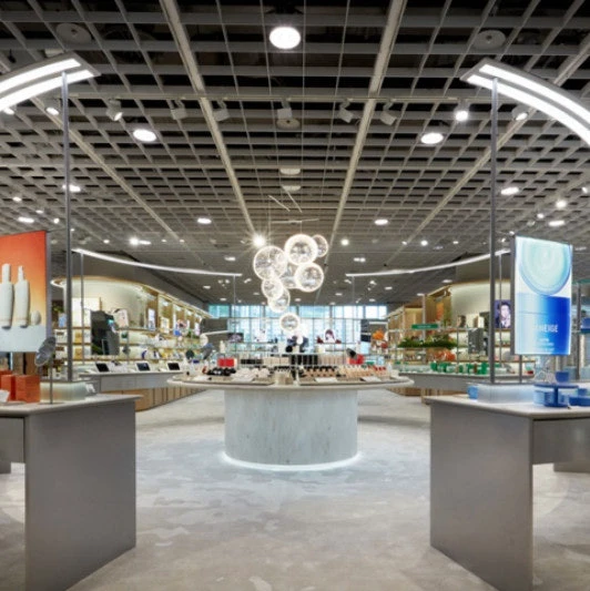 Amore Yongsan flagship interior with brand displays arranged around a central beauty table