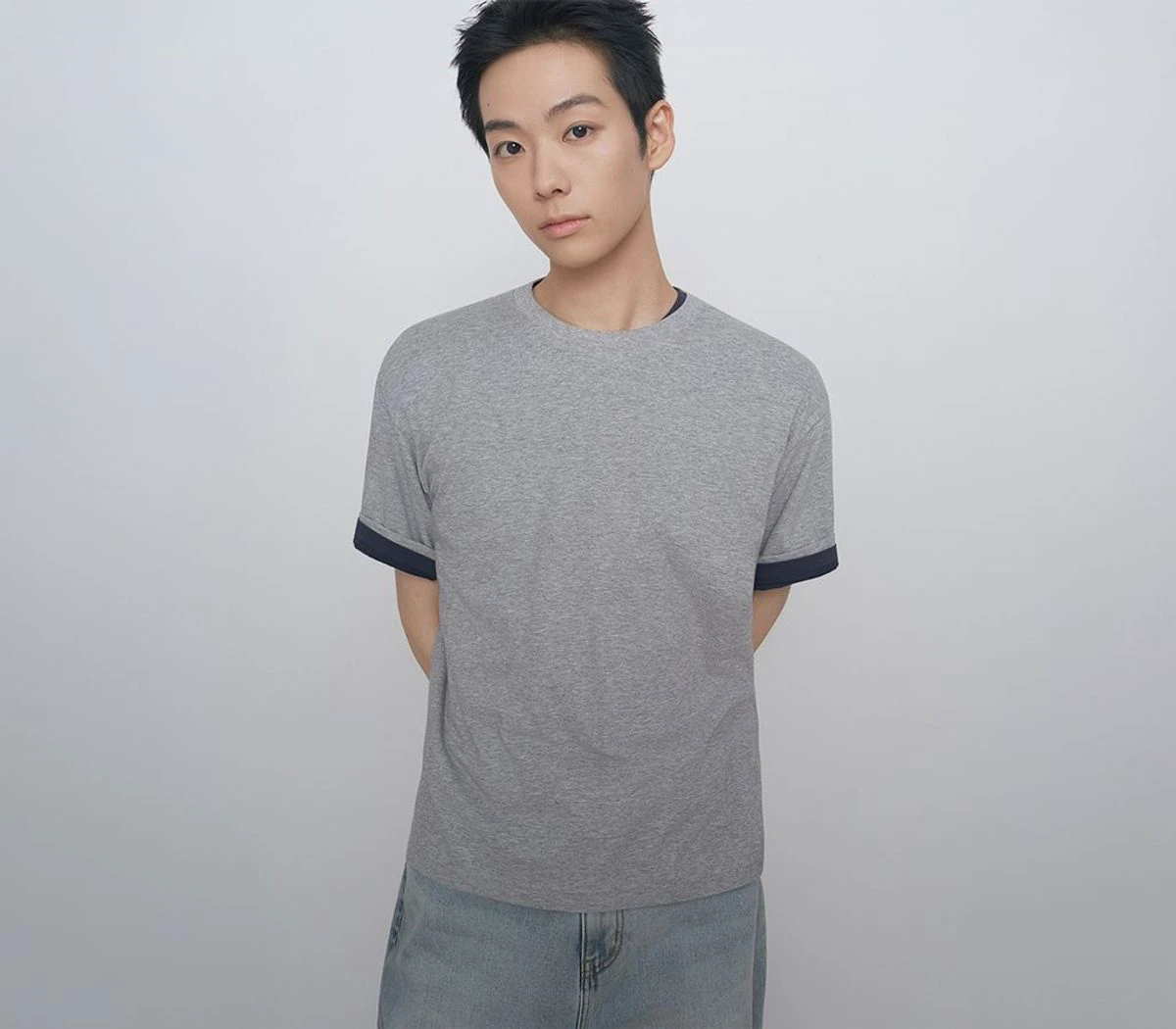 Model wearing a simple gray Musinsa Standard crewneck T-shirt against a light gray background