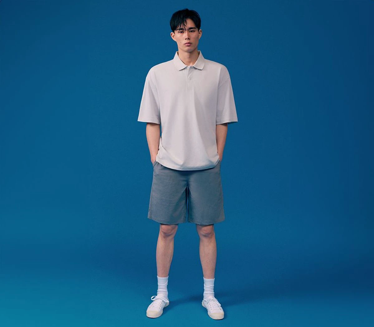 Full-body Musinsa Standard outfit with a pale relaxed polo, gray shorts, socks, and sneakers