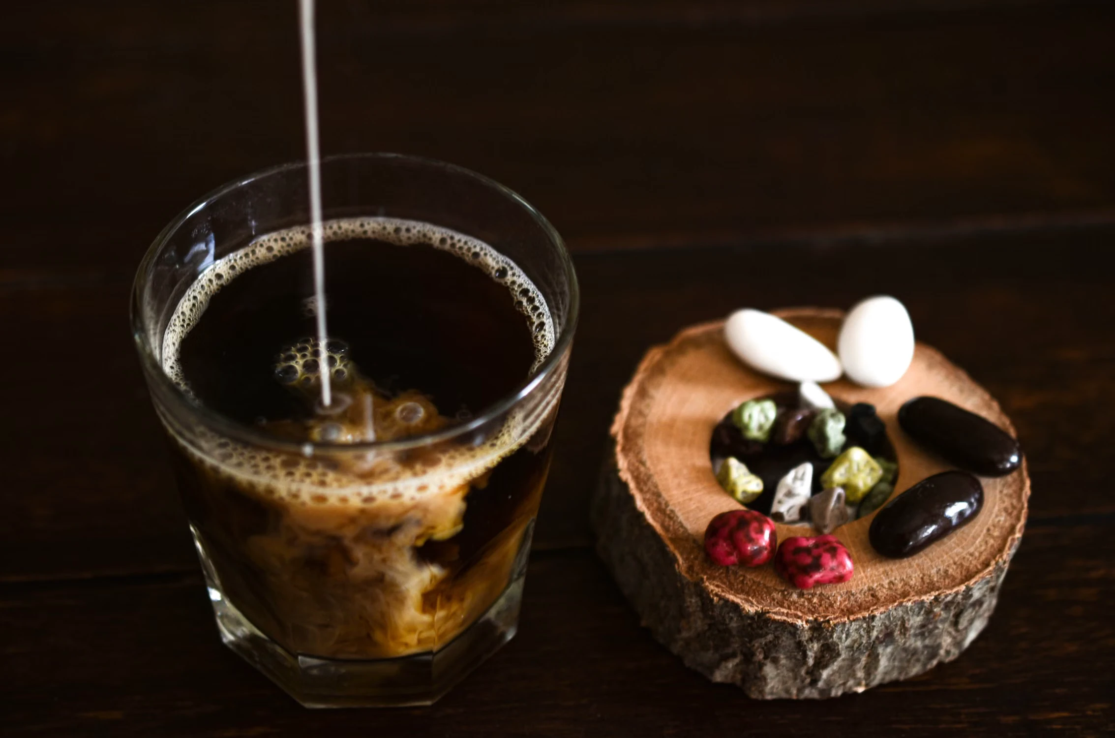 Milk being poured into a glass of coffee as a reference for sweet coffee-milk flavor