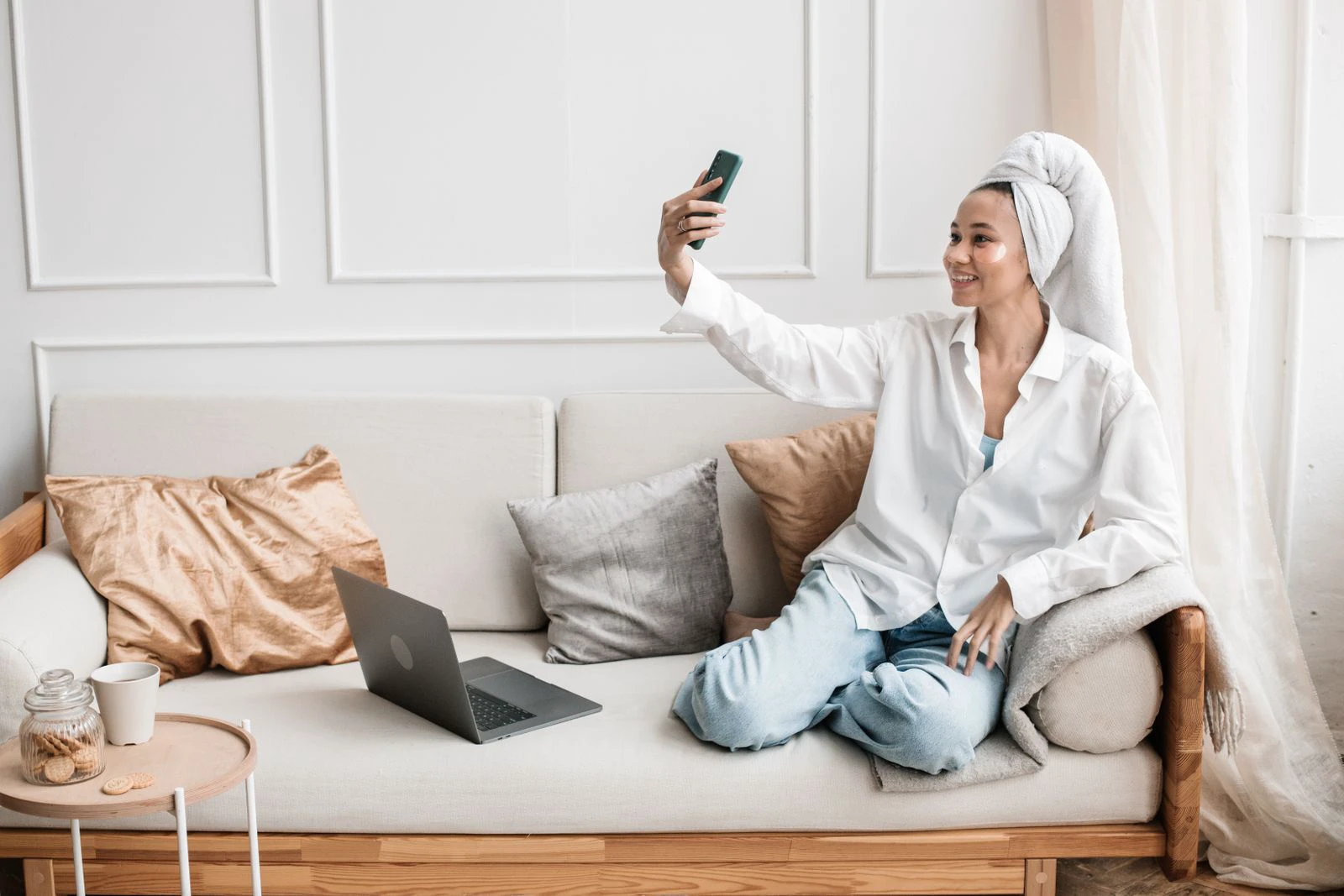 Person taking a phone selfie in natural indoor light before making a skin-treatment decision