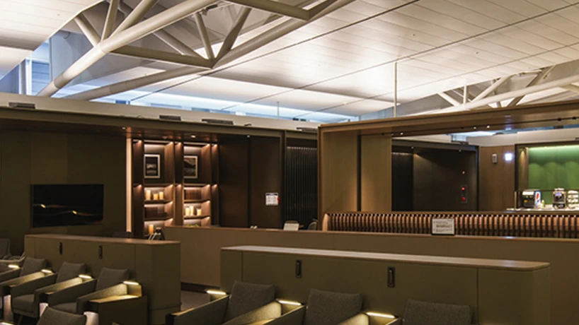 Rows of upholstered lounge chairs beneath exposed roof beams at Incheon Airport