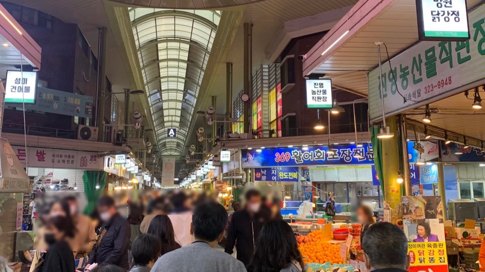Covered aisle and produce stalls inside Mangwon Market in 2026