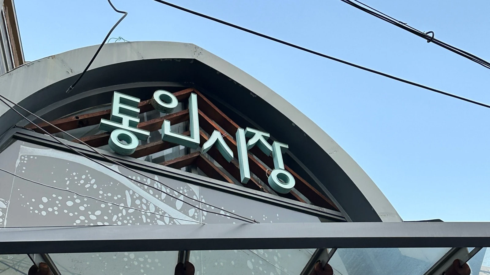 Korean sign above the covered entrance to Tongin Market in 2026