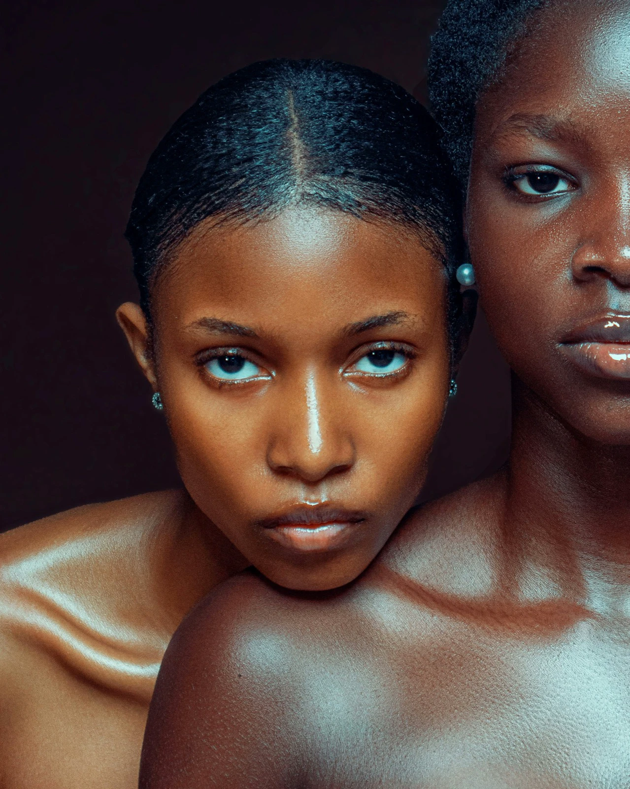 Close portrait of two people with visibly different dark skin tones