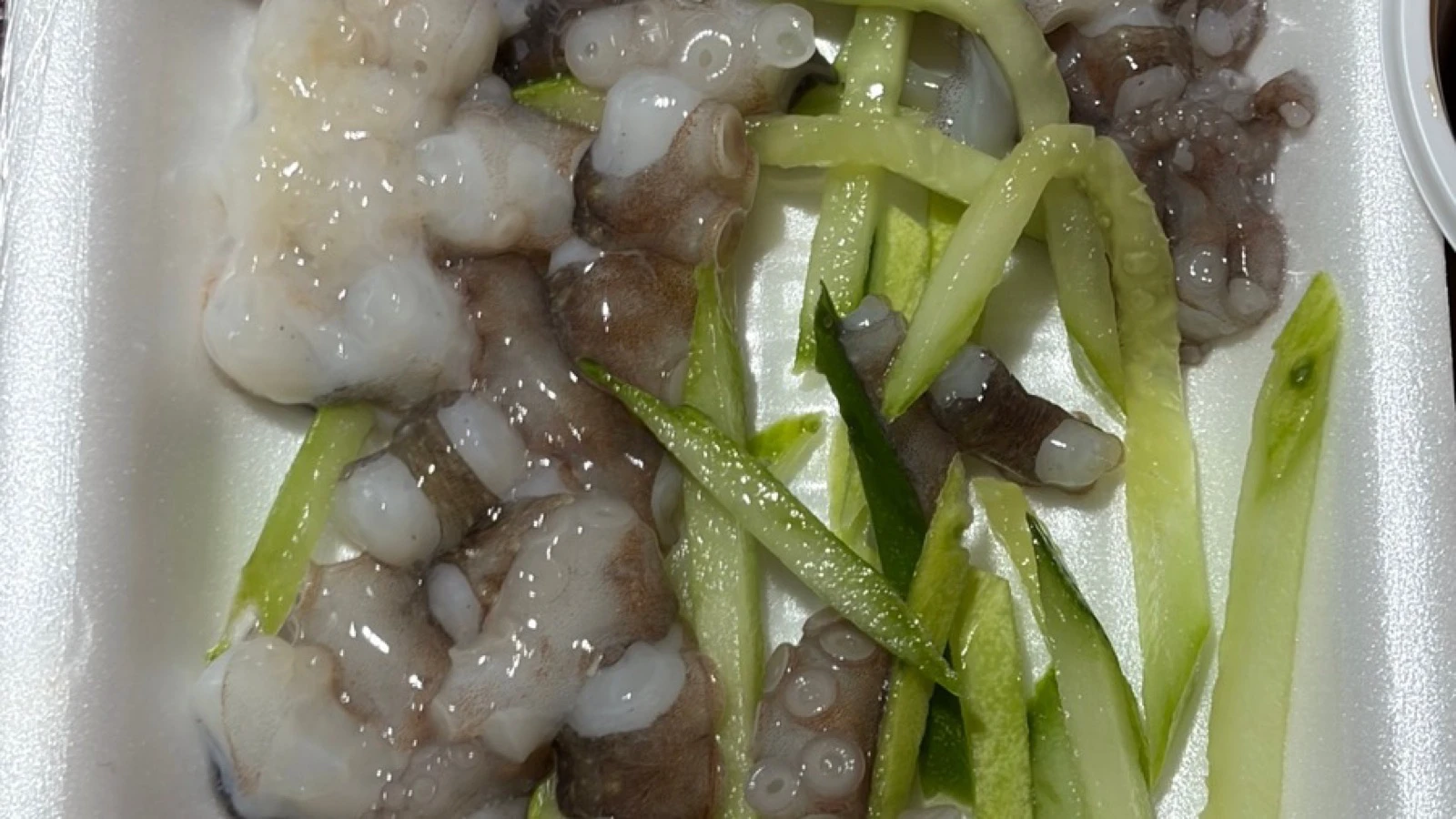 Freshly cut sannakji pieces with visible suction cups and cucumber strips