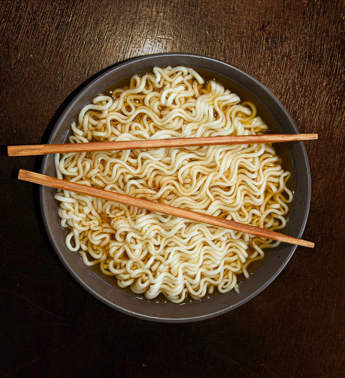 Bowl of cooked instant noodles with wooden chopsticks